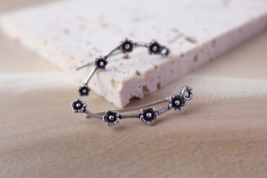 Nature- and sky-inspired brass ear climber earrings with floral, star and vine designs