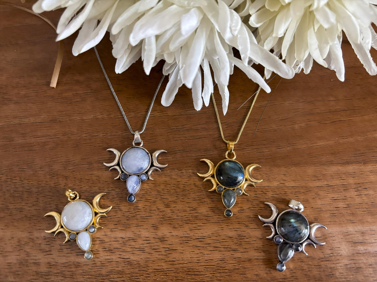 Triple Goddess pendants with moonstone and labradorite under white chrysanthemums