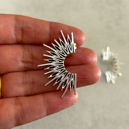 Brass Sunburst Stud Earrings — Solar Flare in silver plate, held in hand showing size