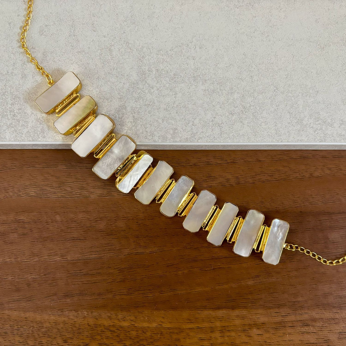 Close-up of eleven gold-edged mother of pearl panels and curb chain on the Tidal Lustre choker necklace