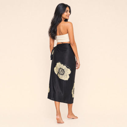 Close-up of the cream passion-flower print and black satin drape on the Midnight Bloom sarong