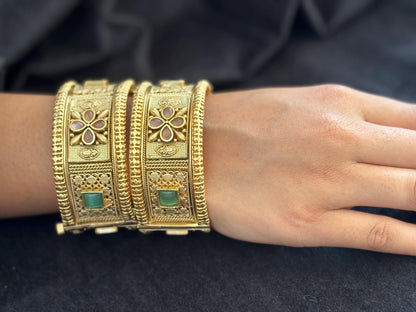 Emerald Bloom Rajwadi Kada - Gold polished bridal kada with floral pastel petal motifs and green square stones in embossed temple styling.