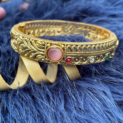 Close-up of shimmering pink cabochon and leaf-and-vine relief on Two-Way Brass Kada Bangle — Twin Dawn