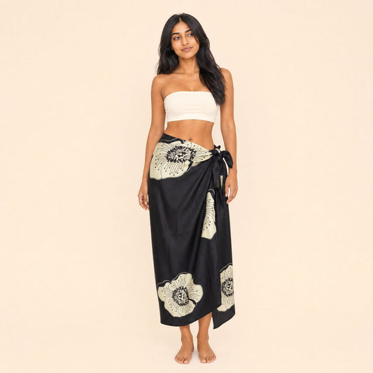 Black floral satin sarong by Boho Mantra, cream passion-flower blooms on black, worn as a side-tie wrap skirt