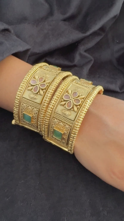 Emerald Bloom Rajwadi Kada - Gold polished bridal kada with floral pastel petal motifs and green square stones in embossed temple styling.