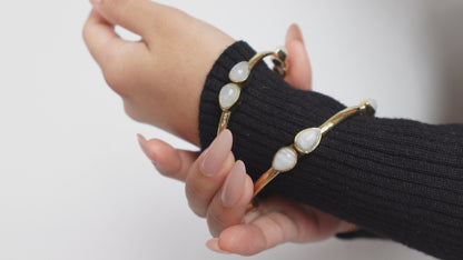 Teardrop Moonstone Brass Cuff - Sleek gold-tone brass cuff with teardrop moonstones in minimalist design.